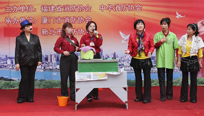 新北市婦女宣導(dǎo)隊在廈門市中山路現(xiàn)場表演家庭防火小品。