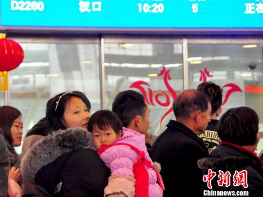 一名兒童在母親的懷抱中候車。　吳正琪　攝
